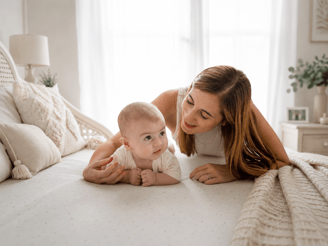 A first-time parent gently dressing his/her newborn in a soft bamboo romper.